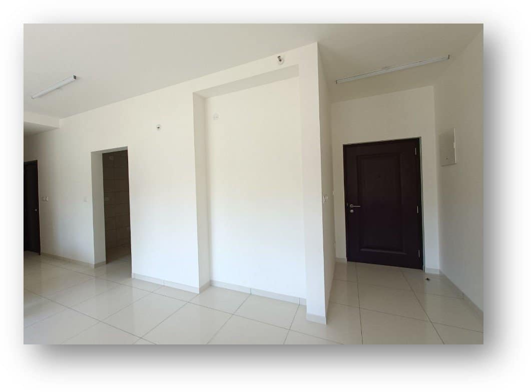 Empty residential apartment in Bangalore, featuring white walls, tiled flooring, and multiple doorways, poised for a complete interior design transformation by Olangana Design.