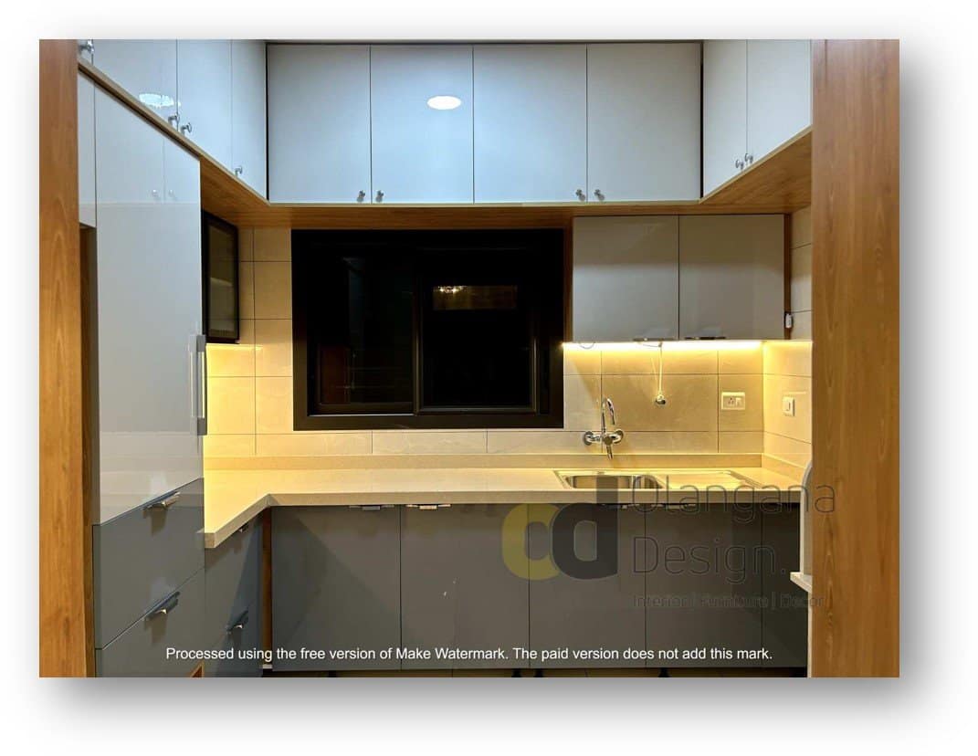 Modern kitchen interior design by Olangana Design in Bangalore featuring sleek grey and white cabinets, under-cabinet lighting, and a contemporary sink area.