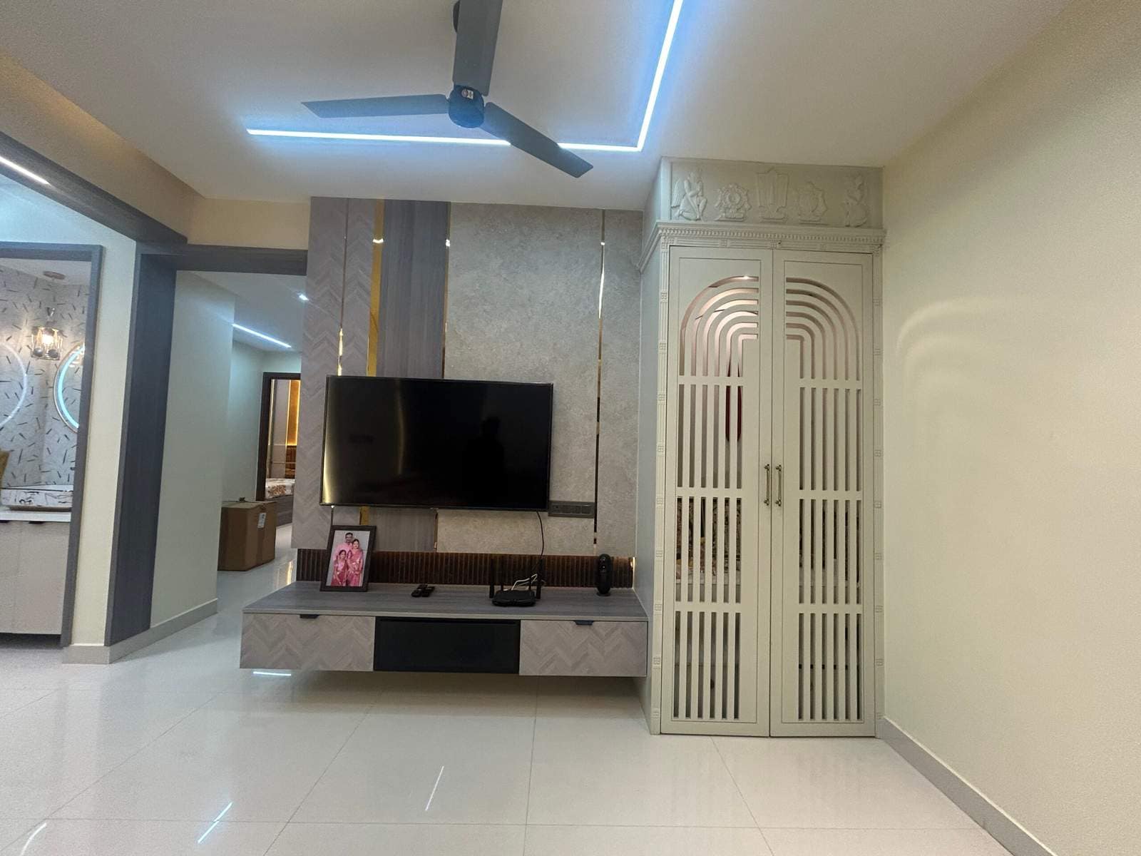 Modern pooja cabinet with doors in living room near TV unit in Bangalore home by Olangana Design’s.