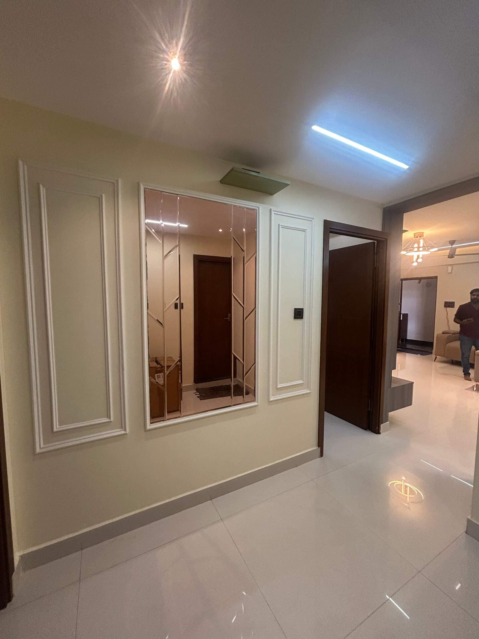 Stylish hallway wall design with classic moulding panels and mirror accent feature by Olangana Design’s.