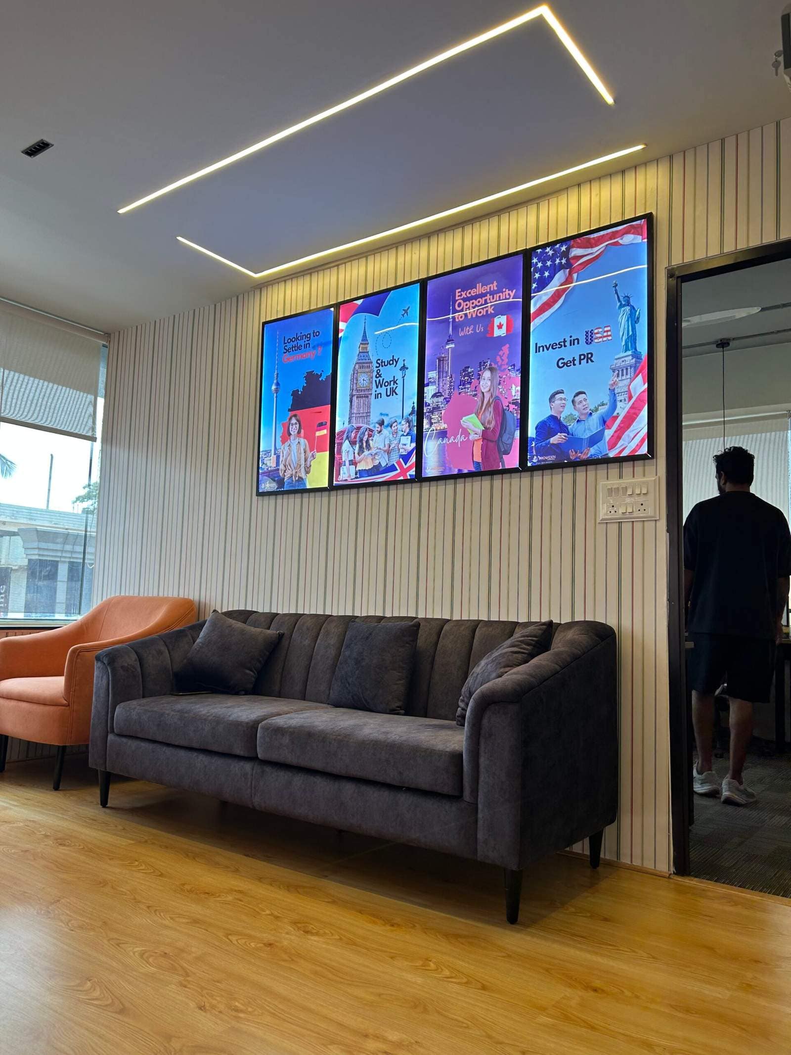 Office conversation seating area in Bangalore with two sofas facing each other and three wall art frames by Olangana Designs