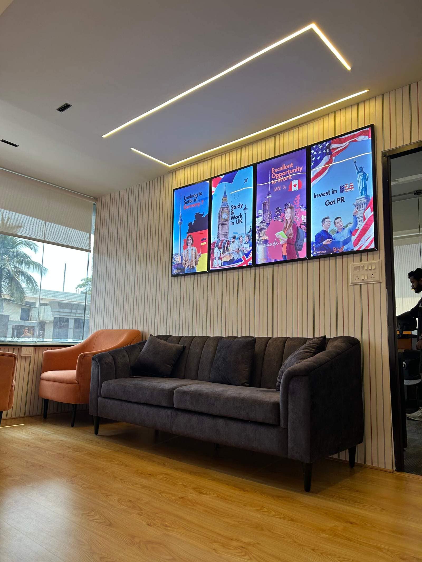 Office conversation seating area in Bangalore with two sofas facing each other and three wall art frames by Olangana Designs