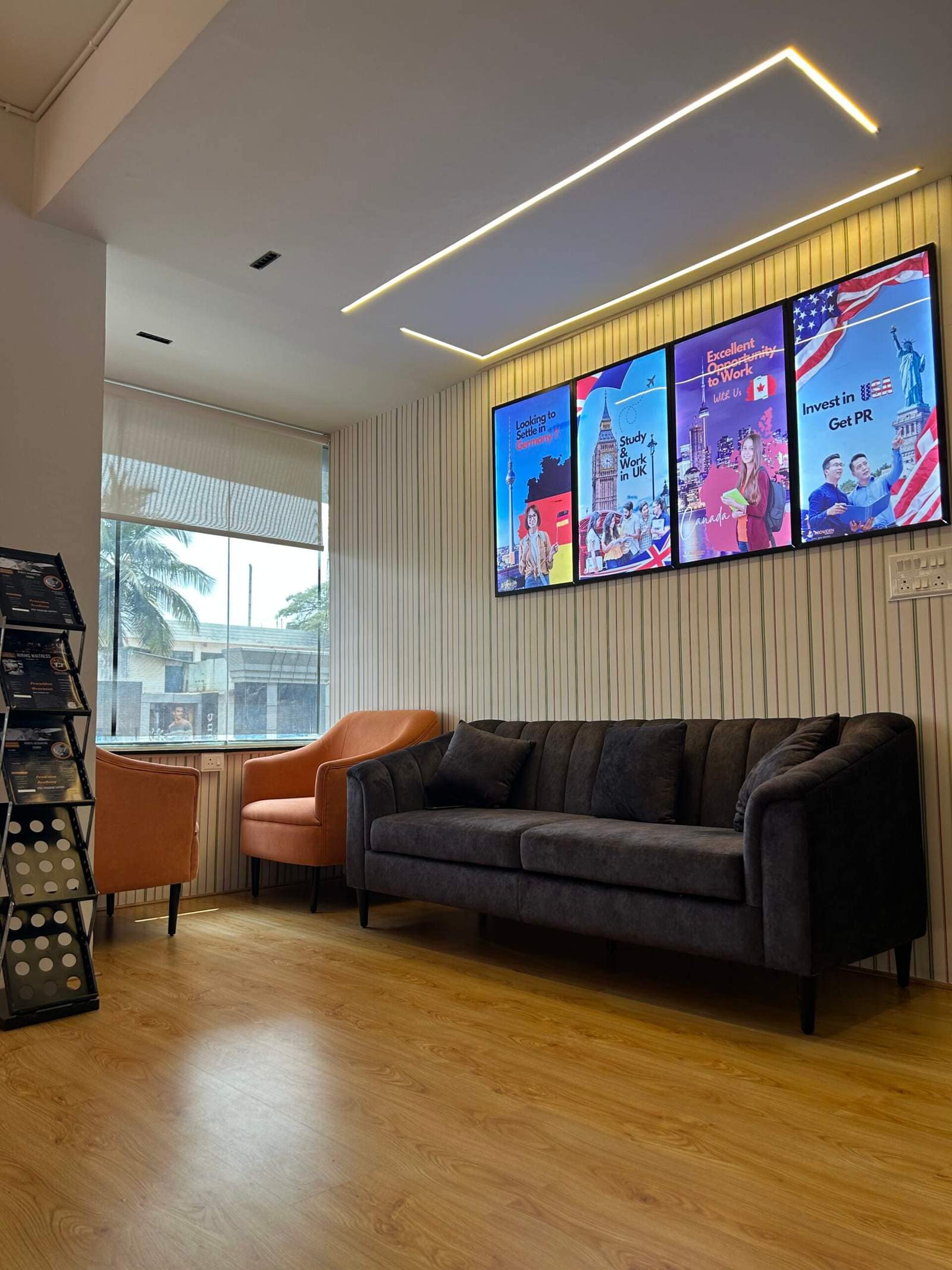 Office hall interior in Bangalore with two sofas facing each other and three decorative wall paintings by Olangana Designs