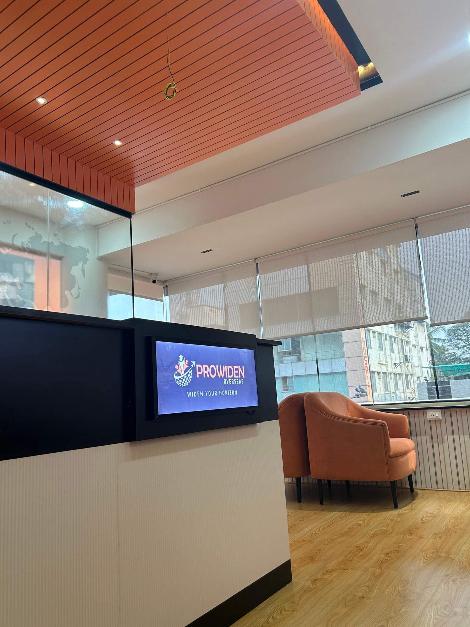 Office hall seating arrangement in Bangalore with two sofas facing each other beside a window for conversation by Olangana Designs