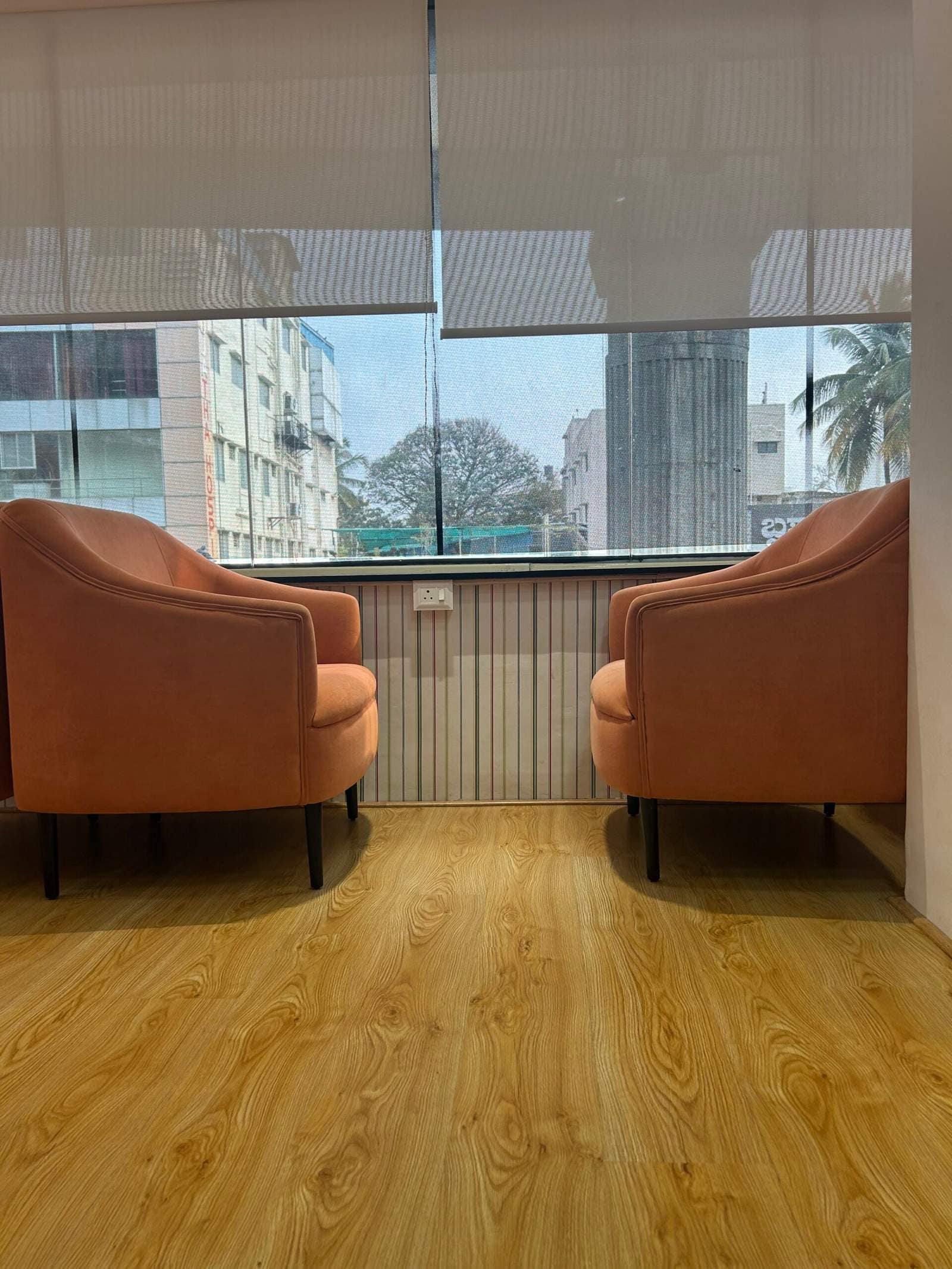 Office hall conversation seating with two sofas near window in Bangalore interior design by Olangana Designs