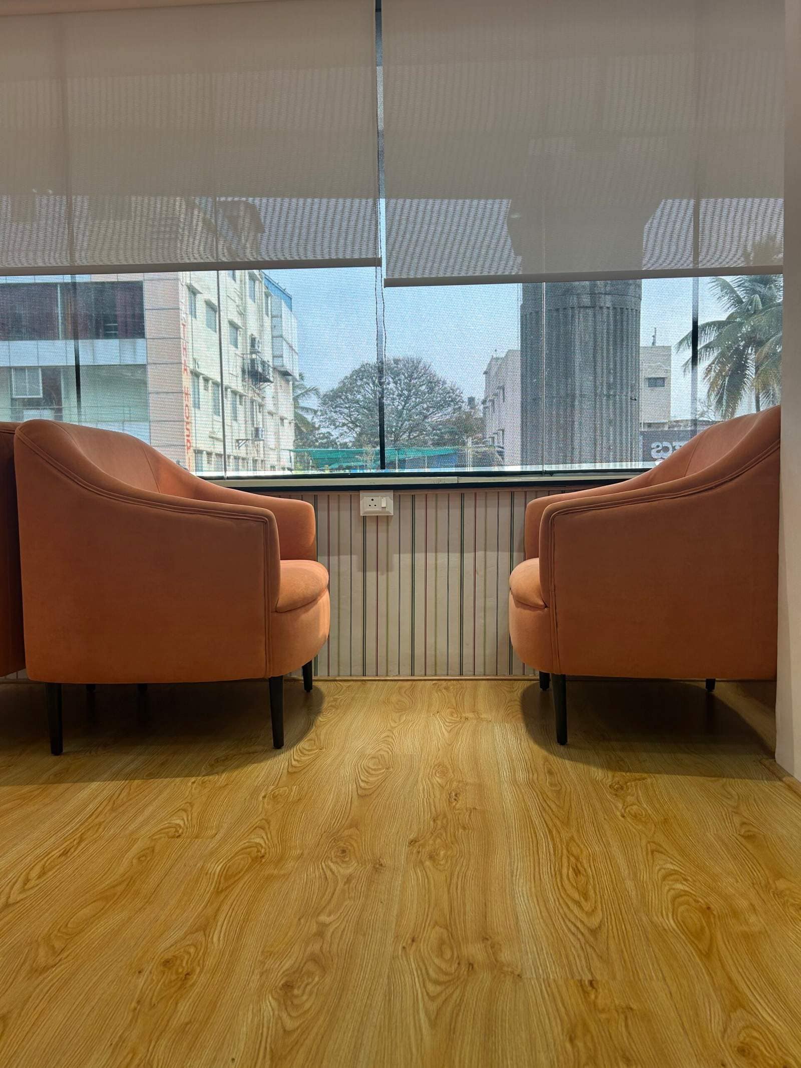 Modern office lounge in Bangalore with opposite facing sofas near window seating area by Olangana Designs