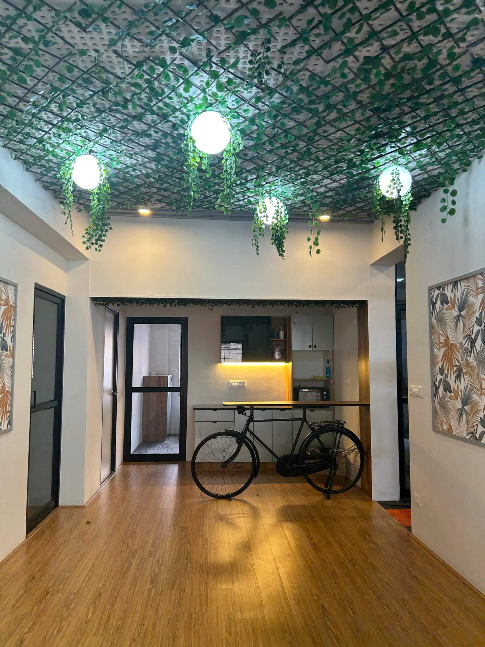 Creative office interior design in Bangalore with decorative bicycle feature, modern cabinets, and warm lighting by Olangana Designs