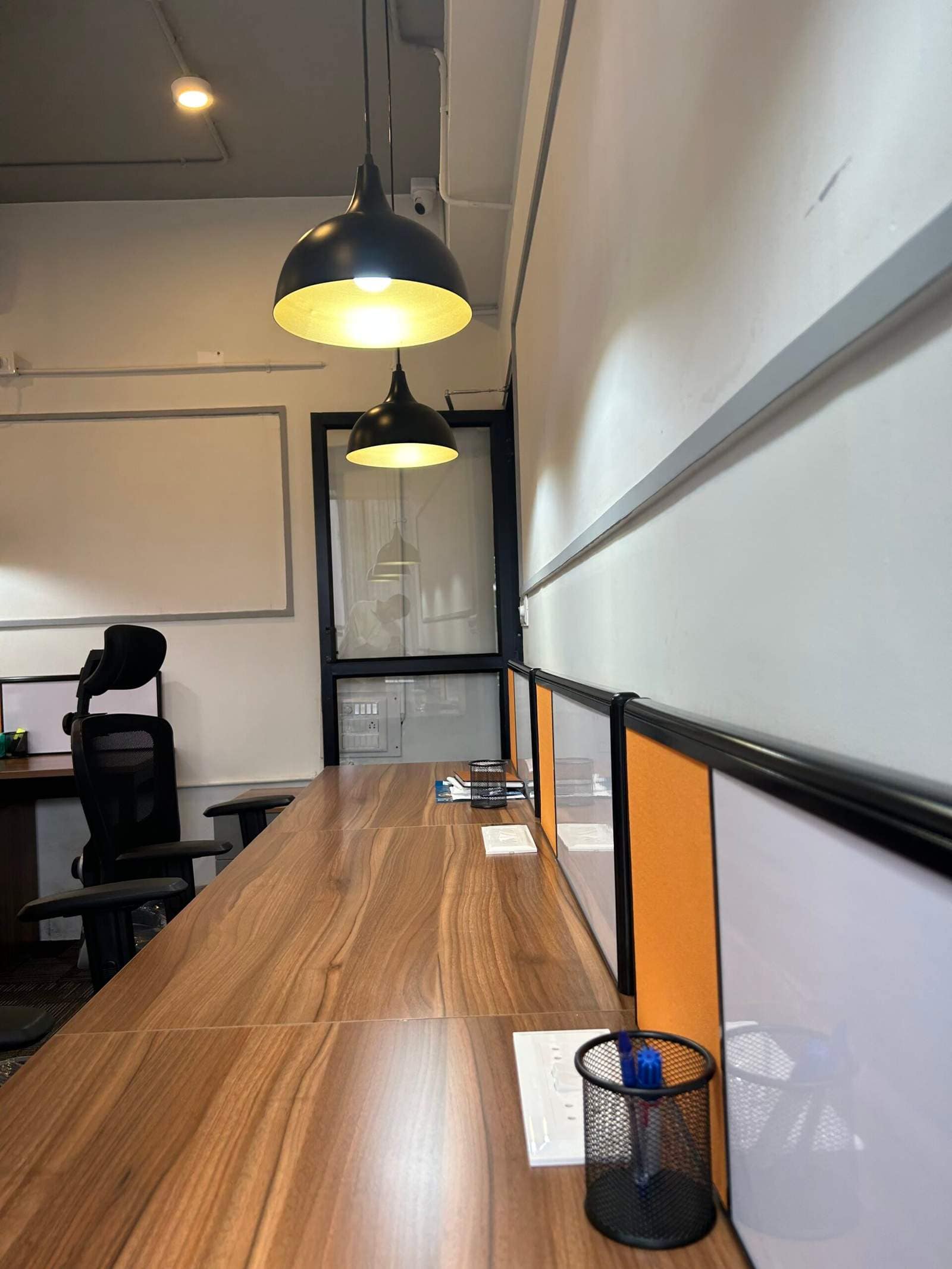 Olangana Design’s presents a small corporate office cabin interior in Bangalore with comfortable chairs, modern lighting, and a clean workspace layout.