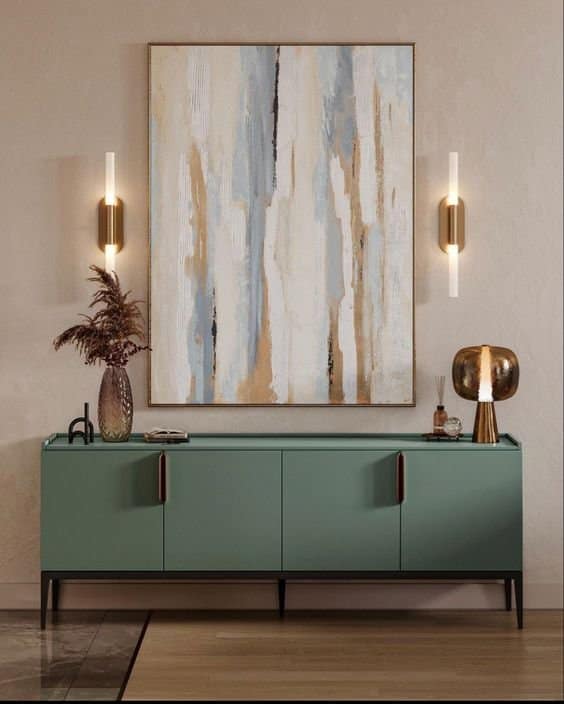 Modern living room interior with sage green sideboard, abstract art, and contemporary wall sconces by Olangana Design in Bangalore.