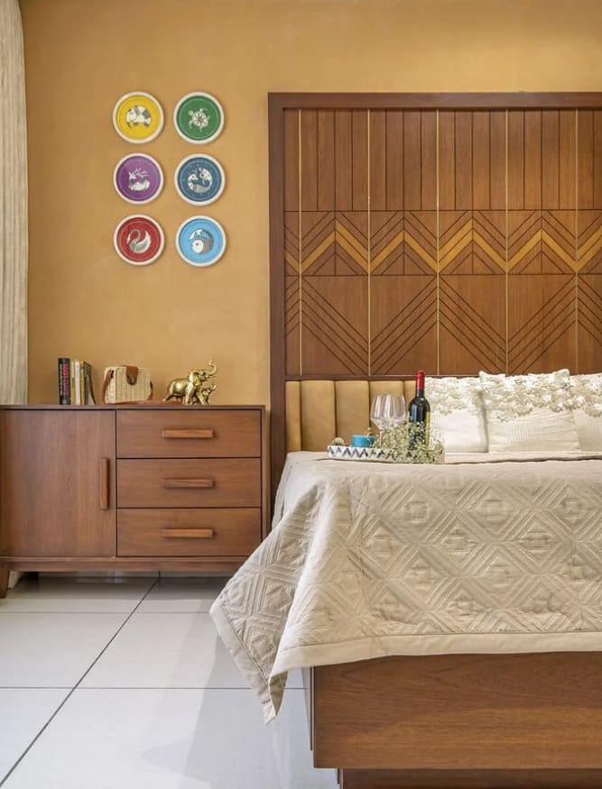 Luxurious modern bedroom interior design by Olangana Design in Bangalore featuring a wooden headboard, beige bedding, and decorative wall art for a sophisticated living space.