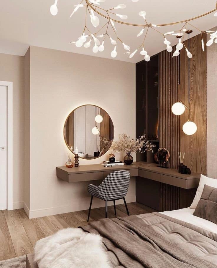 Modern bedroom interior with floating vanity, round illuminated mirror, unique branch chandelier, and stylish wooden accent wall, a premium design by Olangana Design in Bangalore.