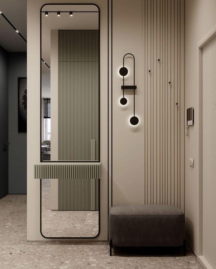 Modern entryway interior design by Olangana Design in Bangalore featuring a full-length mirror, minimalist fluted console, stylish wall lighting, and an upholstered bench, showcasing sophisticated residential interior solutions.