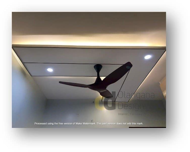 Modern false ceiling interior design featuring elegant cove lighting, recessed spotlights, and a sleek ceiling fan by Olangana Design in Bangalore.