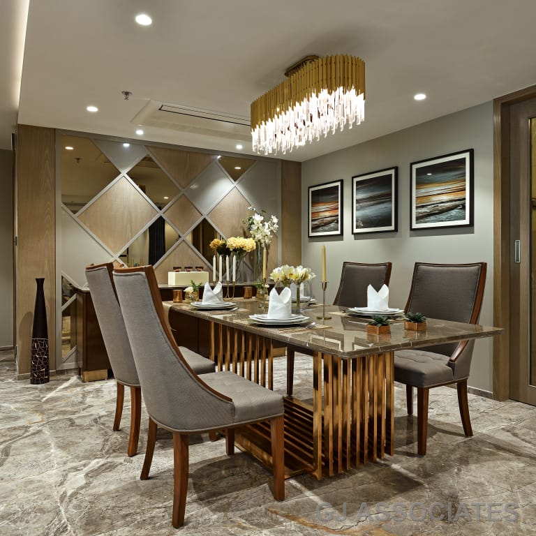 Elegant modern dining room interior design by Olangana Design in Bangalore, featuring a marble dining table, upholstered chairs, and a luxurious crystal chandelier.