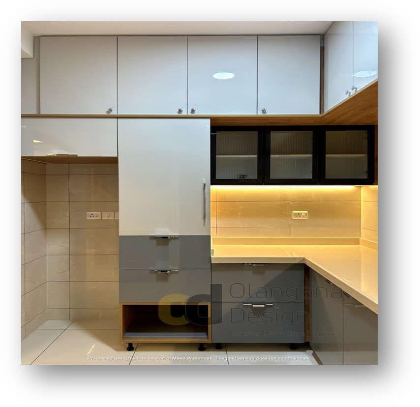 Modern kitchen interior design by Olangana Design in Bangalore, featuring white and grey high-gloss cabinets, sleek hardware, and warm under-cabinet lighting, showcasing stylish and functional kitchen solutions.