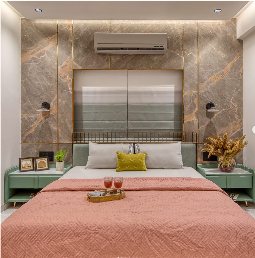 Luxurious modern bedroom interior design by Olangana Design in Bangalore, showcasing a statement marble accent wall with gold detailing, plush king-size bed, and elegant mint green bedside tables.
