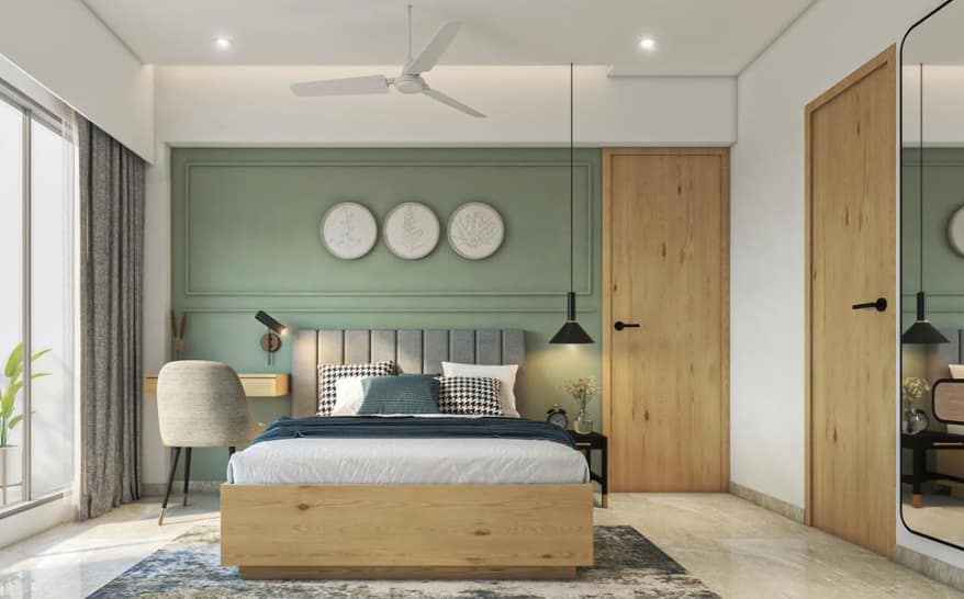 Modern bedroom interior design by Olangana Design in Bangalore featuring a mint green accent wall, wooden bed, stylish lighting, and a functional desk area for a serene living space.