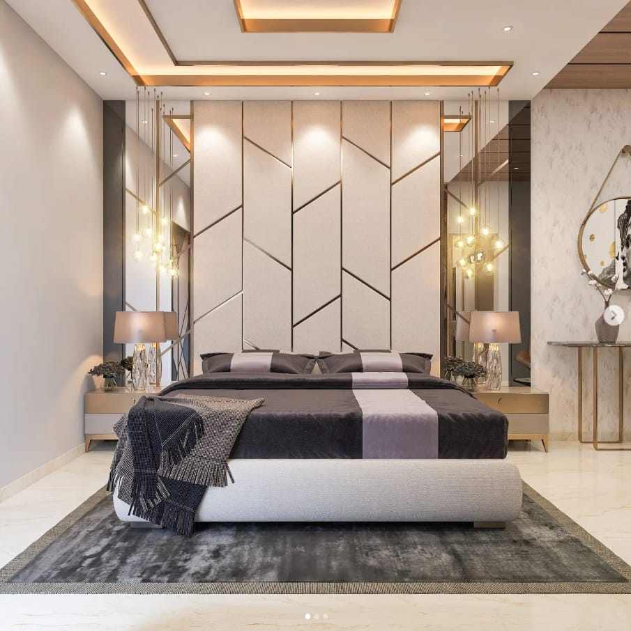 Luxurious modern bedroom interior design by Olangana Design in Bangalore, featuring an upholstered geometric headboard, elegant pendant lighting, and a sophisticated grey and lavender color scheme.