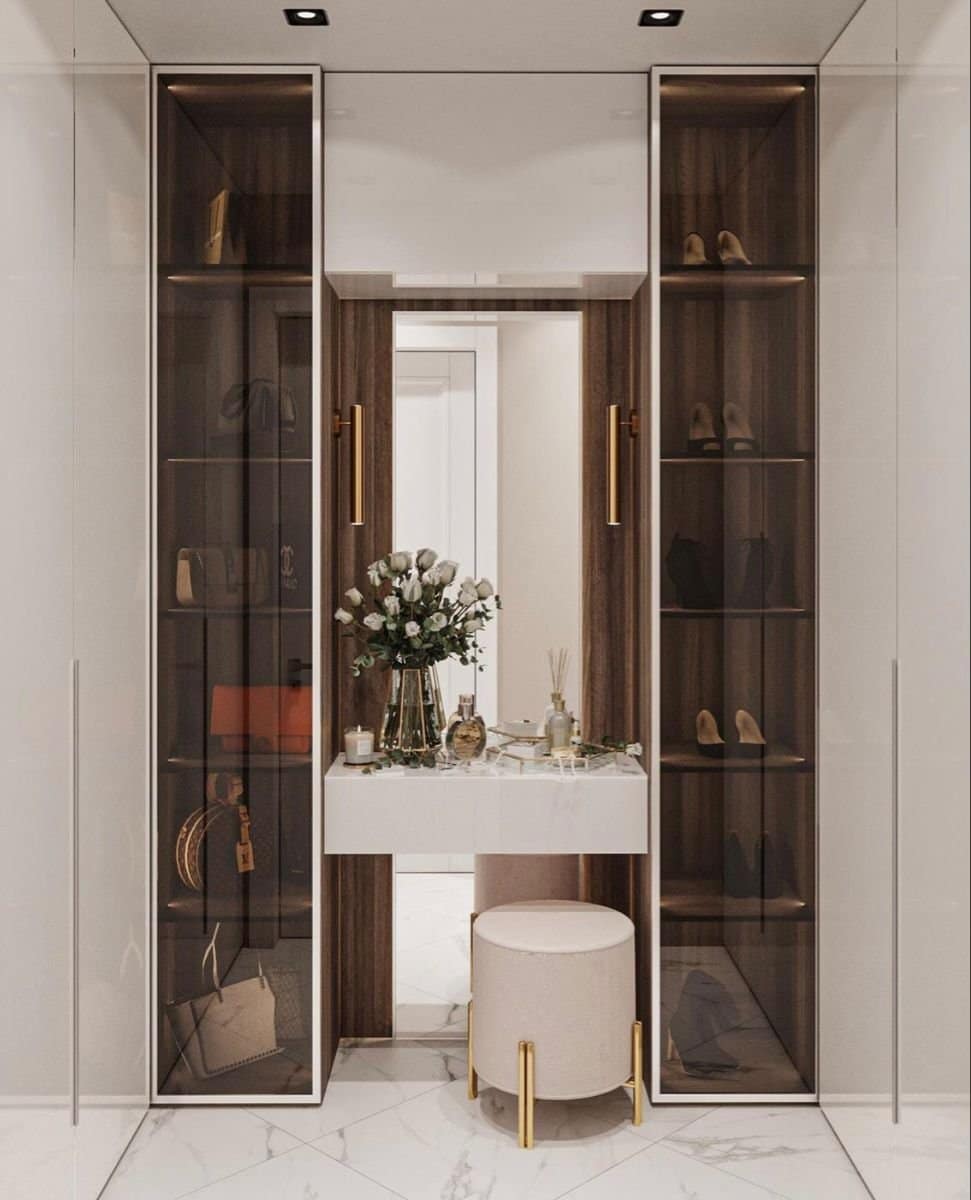 Luxury modern walk-in closet interior design by Olangana Design in Bangalore, featuring display cabinets, vanity table, and elegant decor with marble flooring.