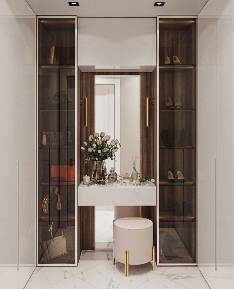 Luxury modern walk-in closet interior design by Olangana Design in Bangalore, featuring display cabinets, vanity table, and elegant decor with marble flooring.